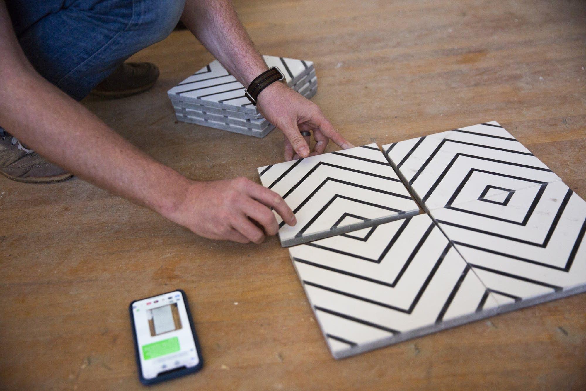 A contractor arranges tile in a pattern.