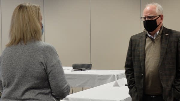 A man and woman wearing masks talk