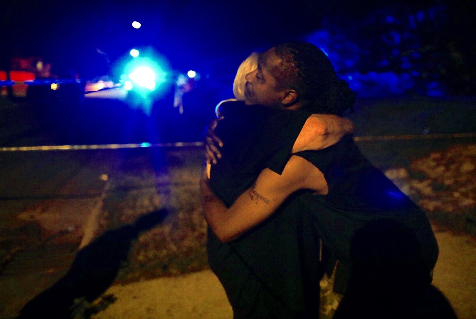 Police chaplain Rev. Linda Koelman hugs Eugene Edwards.