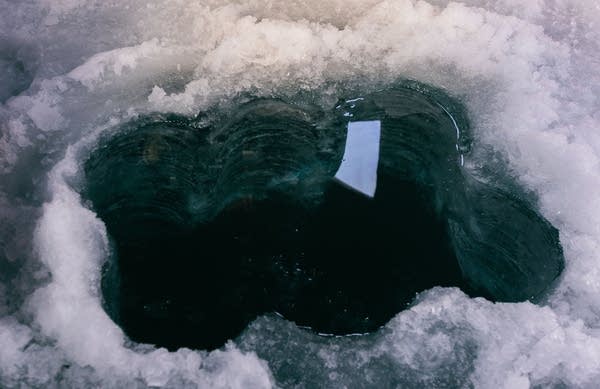 A small hole in a frozen lake.