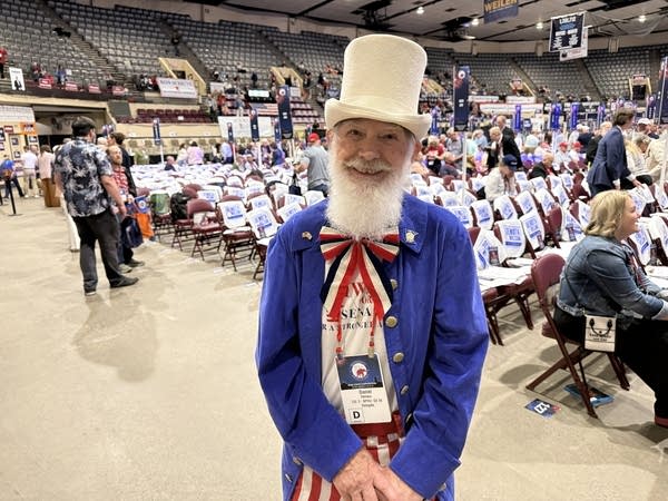 A man poses for a photo dressed in an Uncle Sam costume with a white hat.