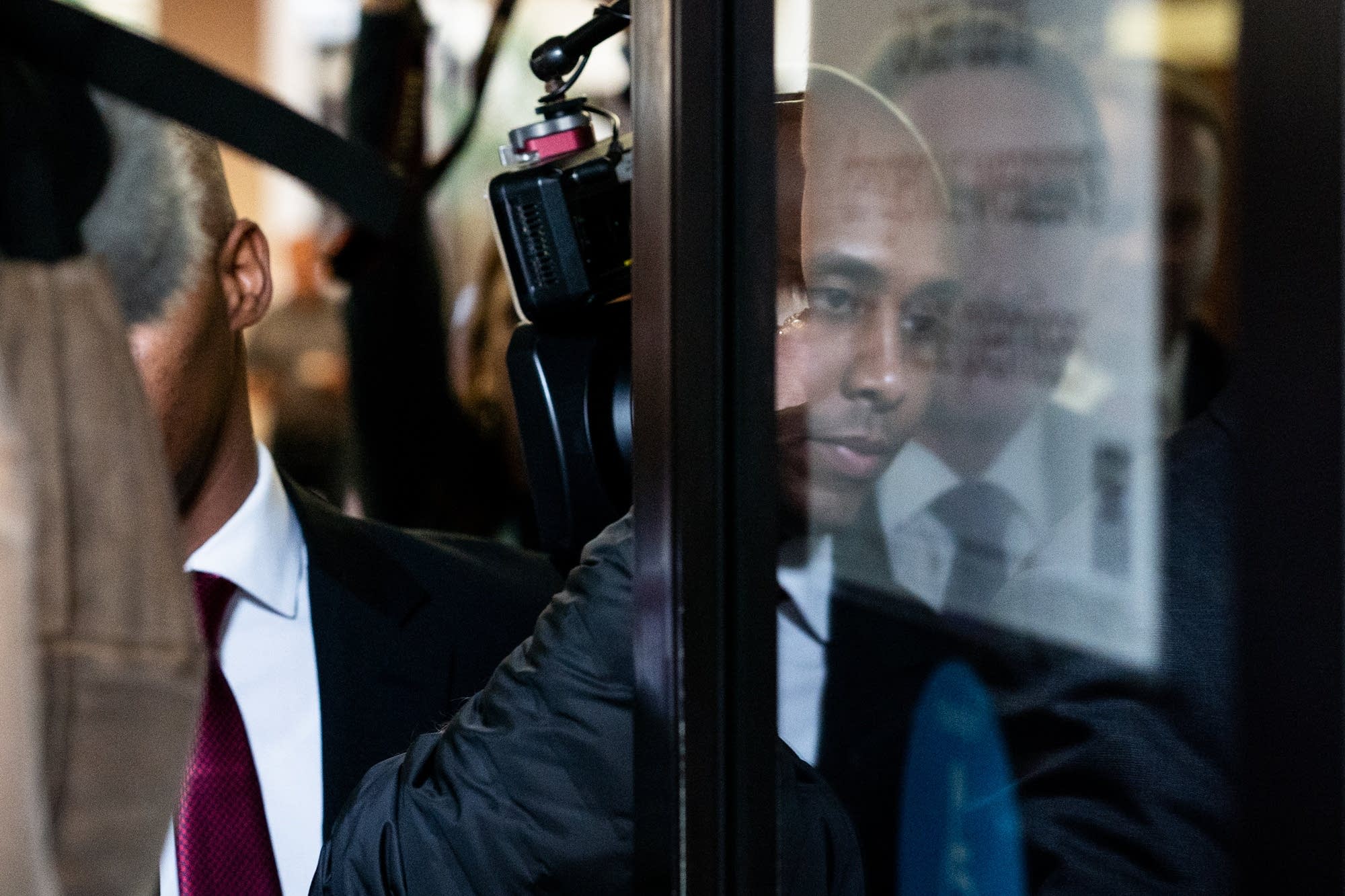 Noor is reflected in a glass door at the courthouse
