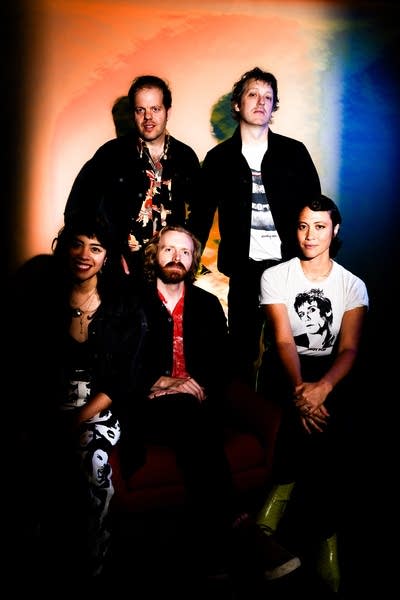 Five people pose for a studio portrait