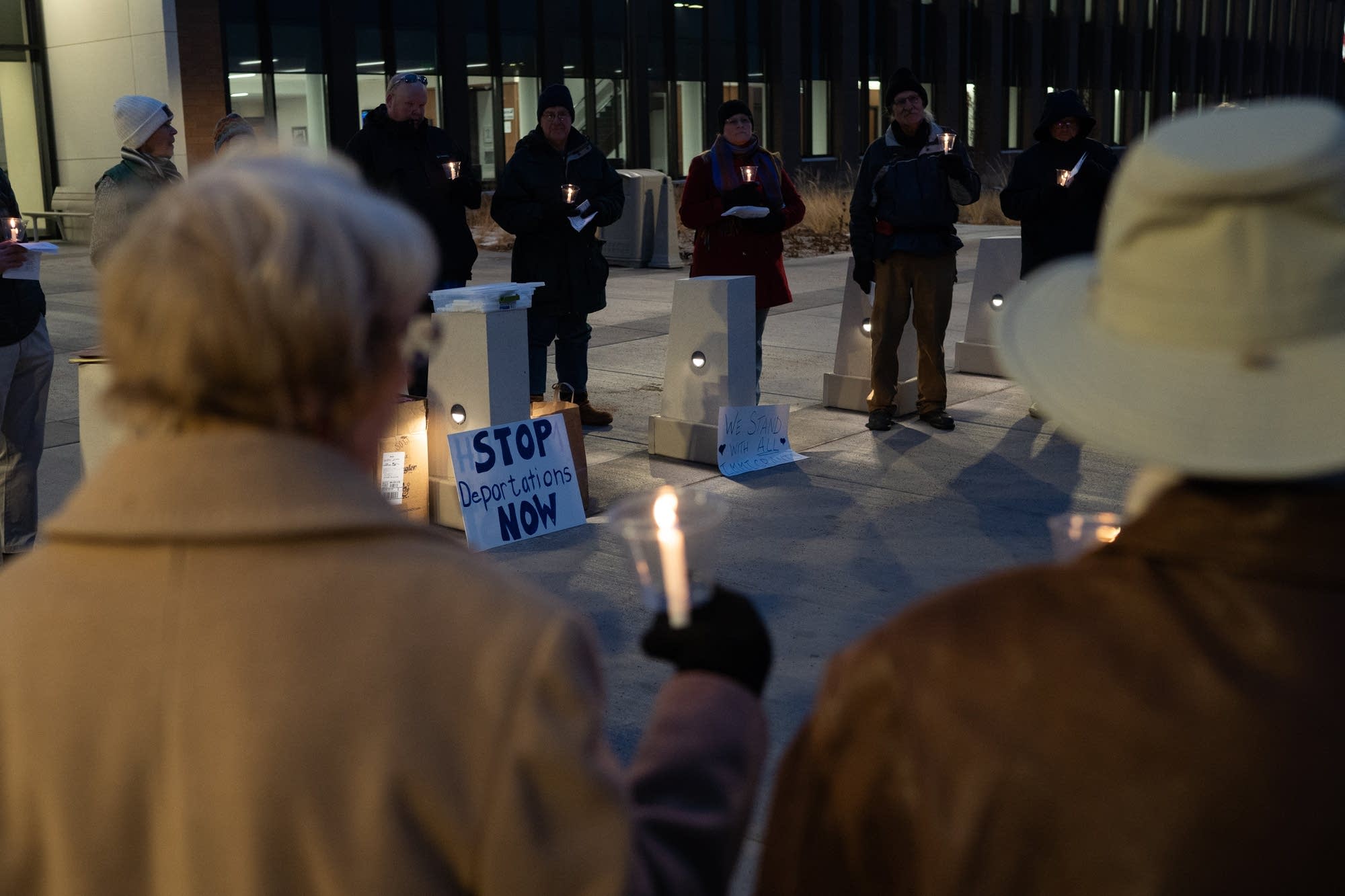 Protesters sing hymns and hold candles outside of the Sherburne County Jail