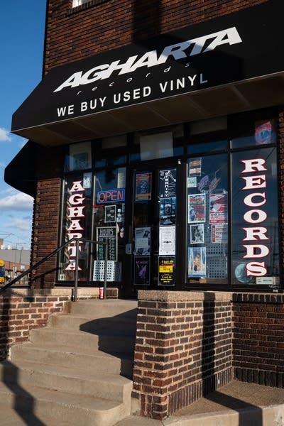 Exterior of a commercial building with signage, awning and posters in the window