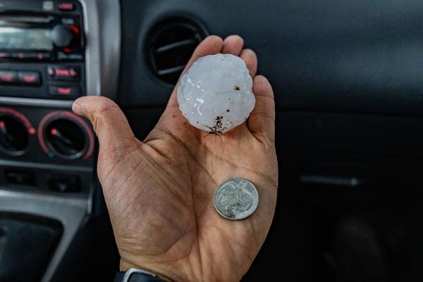 A person holds a large hailstone