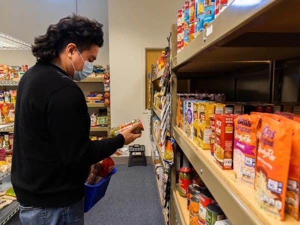 A man wears a mask while looking for groceries