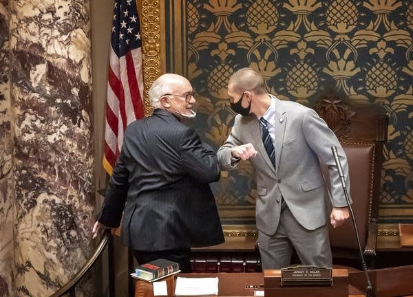 Sen. Jeremy Miller gives Sen. David Tomassoni a congratulatory elbow bump.