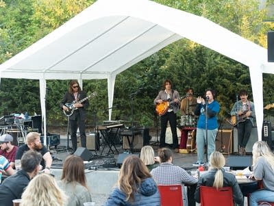 Jill Riley and the band stand on stage in front of the crowd
