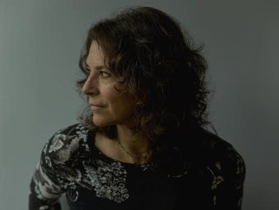 A woman in a floral top poses for a portrait