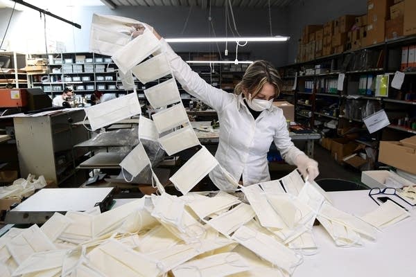 An employee controls surgical masks at a leather workshop turned into a mask factory, close to Vigevano, Lombardy, on March 19, 2020 during the country's lockdown within the new coronavirus pandemic.