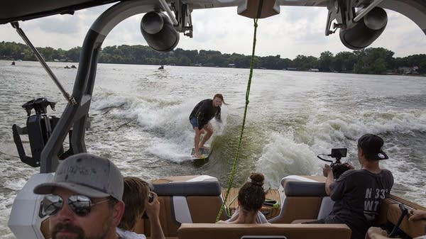 Professional wakesurfer Noah Flegel surfs behind a wakeboat on Lake Minnetonka. 