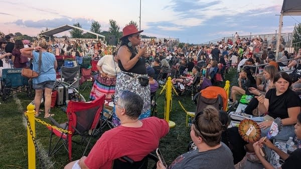 A person uses sign language at a powwow