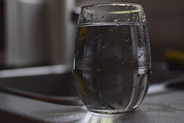 A glass of tap water sits on a counter.