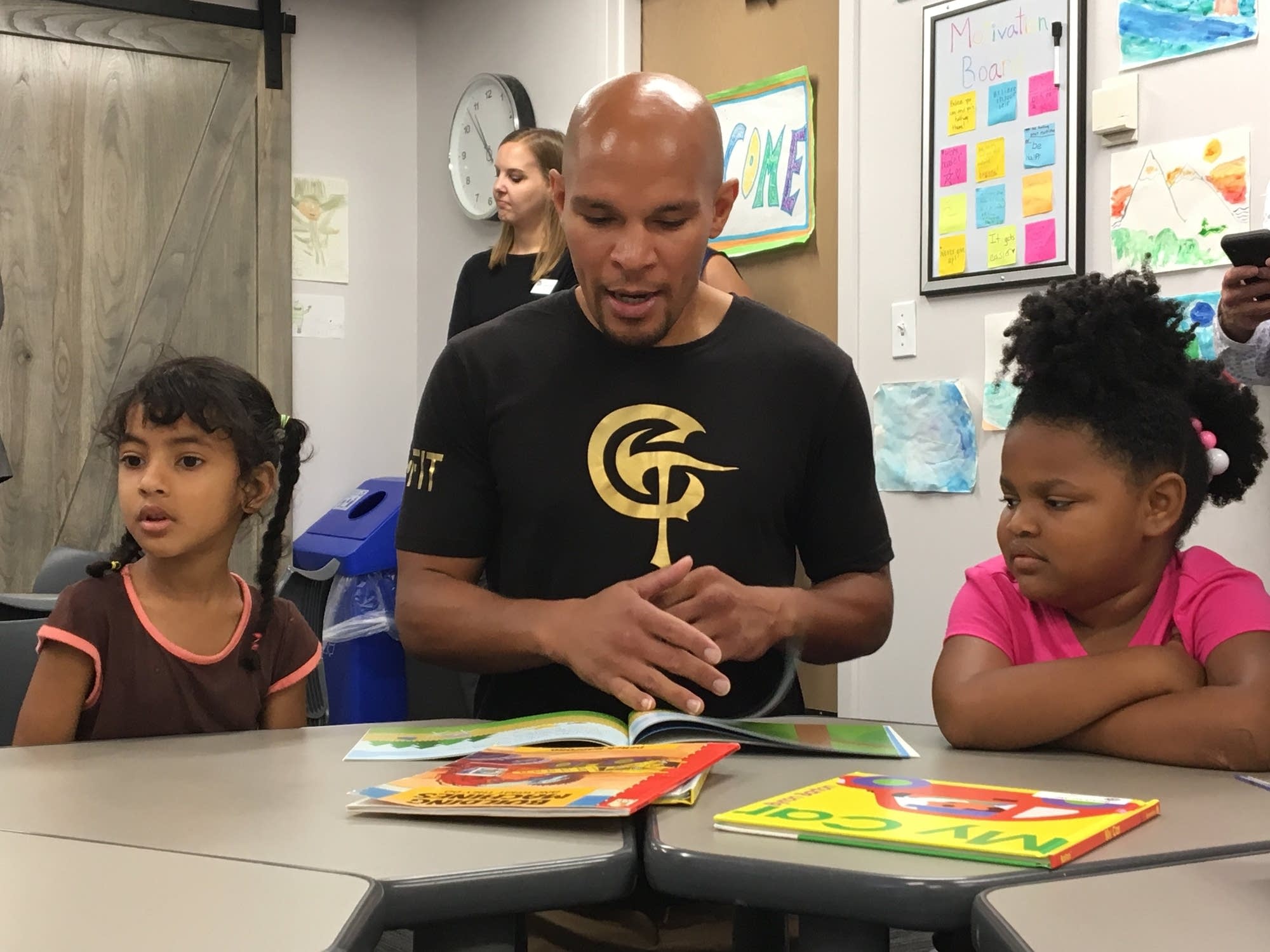 Caleb Truax reads to two preschoolers.