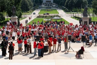 Wide shot of speakers and the crowd at a gun violence rally.