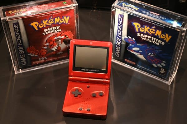 A red Nintendo Game Boy with two Pokemon games.