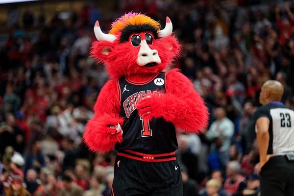 A mascot strides across a basketball court