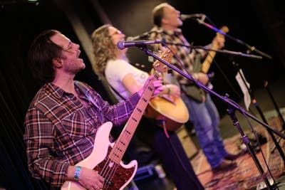 Three musicians performing onstage