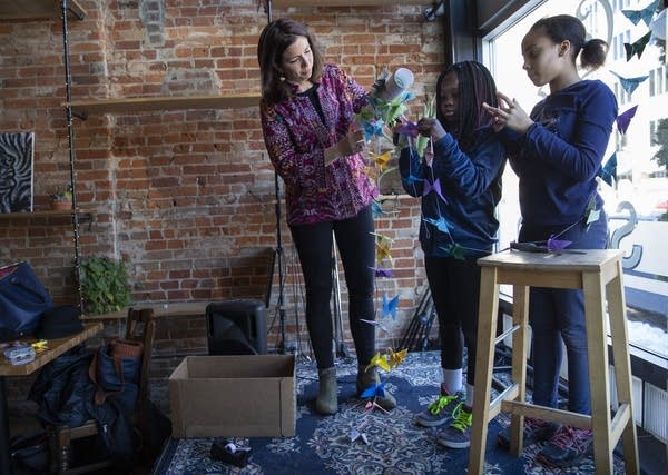 Lida Casper, Lydia Kumbo, 10, and Aliyah Jackson, 11, put up art. 