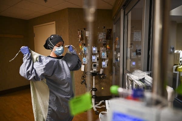 A nurse layers PPE in a hospital