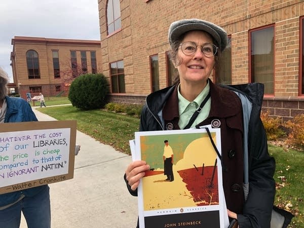 A woman poses with a printed cover of a book.