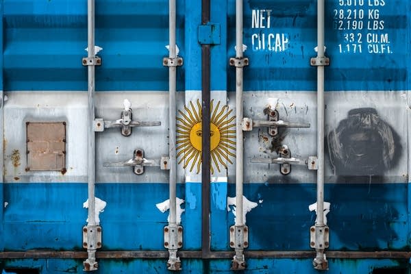 A close-up of a container with the national flag of Argentina. While Argentina's weak currency has made exports more competitive, high inflation has increased the cost of imported goods.