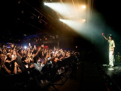 Syd holds up a cup to toast the crowd at Varsity Theater