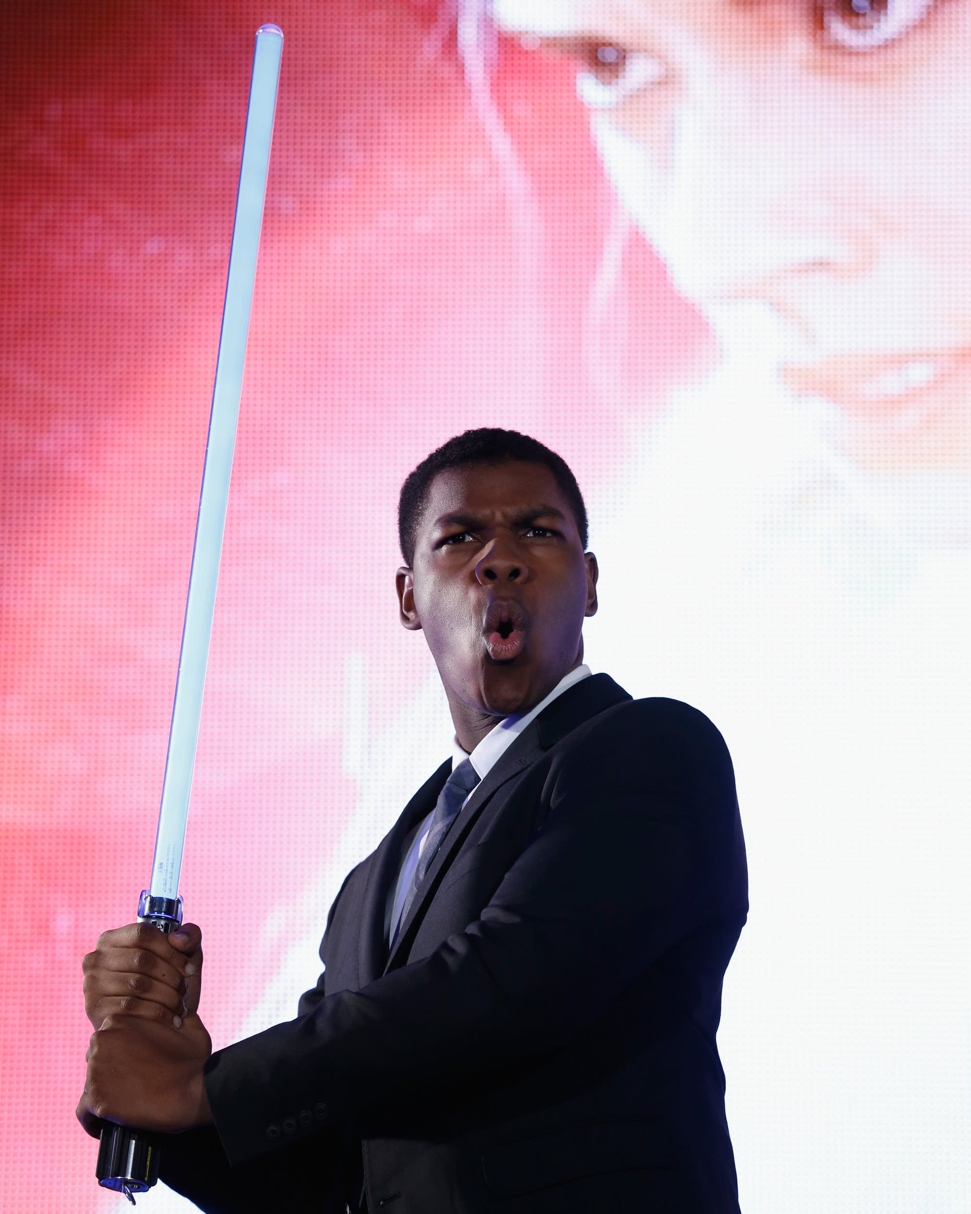 John Boyega with a lightsaber