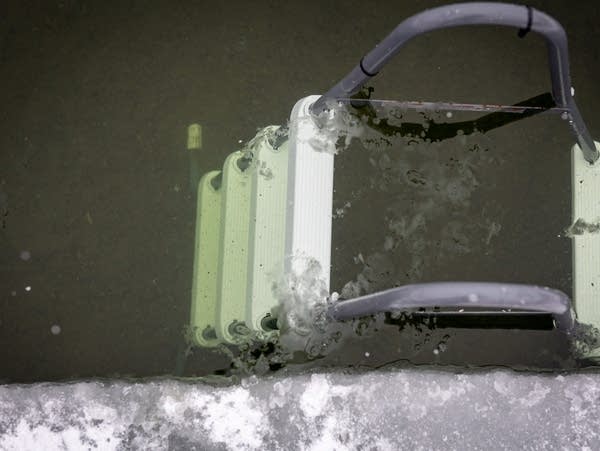 A stepladder is submerged in the icy waters of a lake