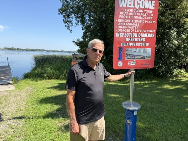 A man stands next to a sign