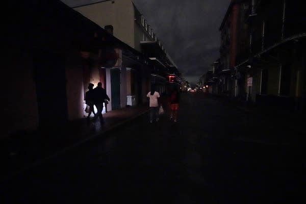 Passers-by on a darkened street. 