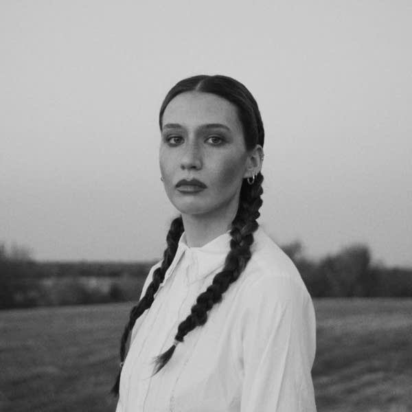 A woman stands on a vast open plain