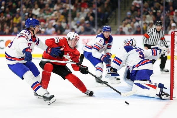 A Switzerland player makes an attempt on goal while surrounded by U.S. players.