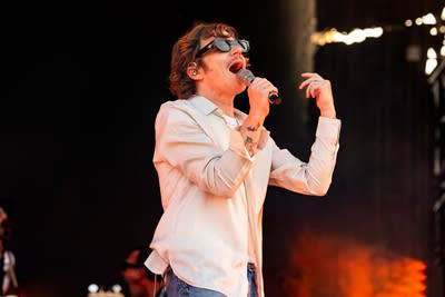Cage the Elephant performing on an outdoor stage.