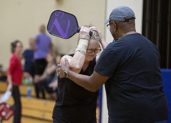 A man reaches out to a woman holding her head in her hands.