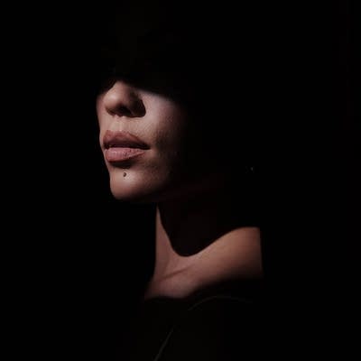 A portrait of a woman's face in heavy shadow