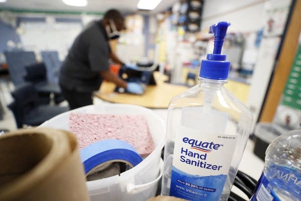 A bottle of hand sanitizer sits in a classroom.