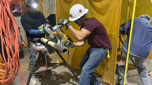 Students practice grinding bevels into steel pipes at STX Metal Trades. 
