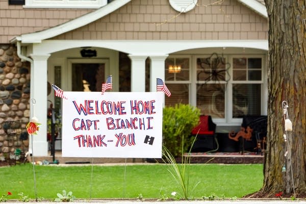 A sign reads "Welcome Home Capt. Bianchi Thank You"