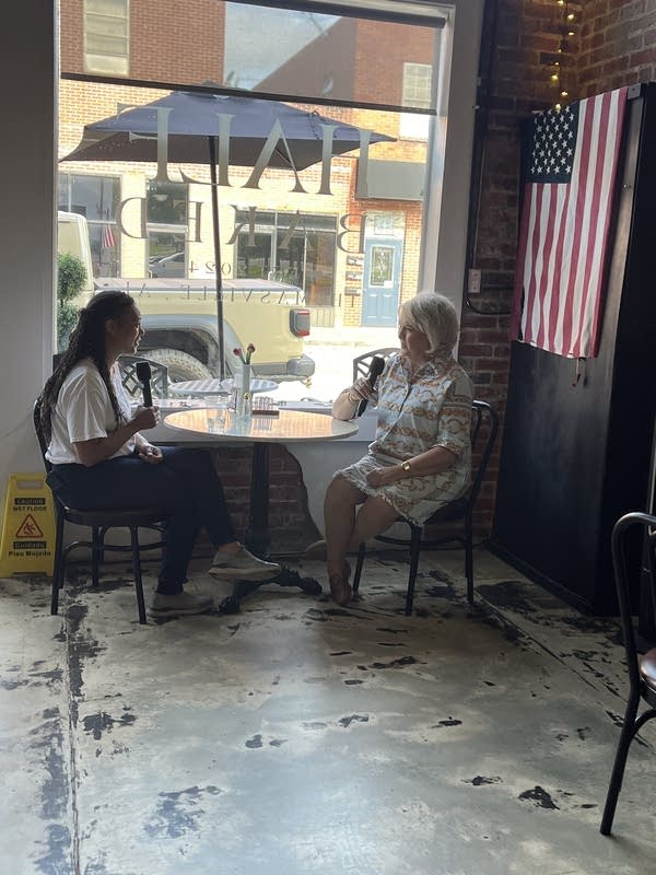 Marketplace Morning Report host Kimberly Adams (left) speaks with Angie Newsom at a table in the bakery.