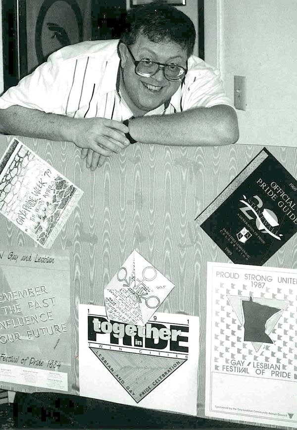 A man stands with a poster in a black and white photo