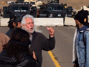 Elder Miles Allard implores protesters to retreat.
