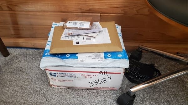Photo of mail and packages sitting under desk chair in office