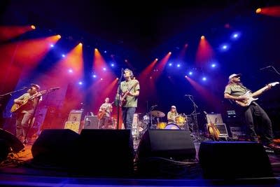 A band performing onstage in a large music venue