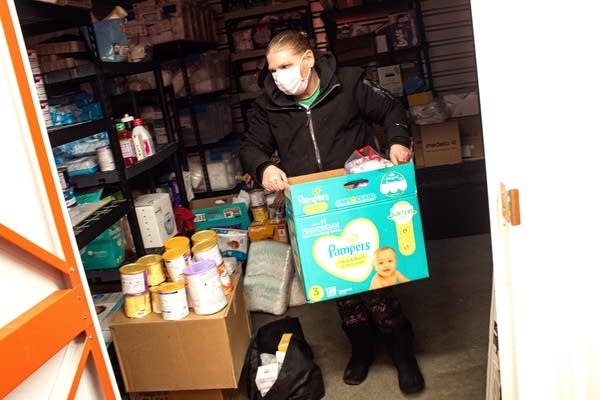 A person carries a box of baby supplies.