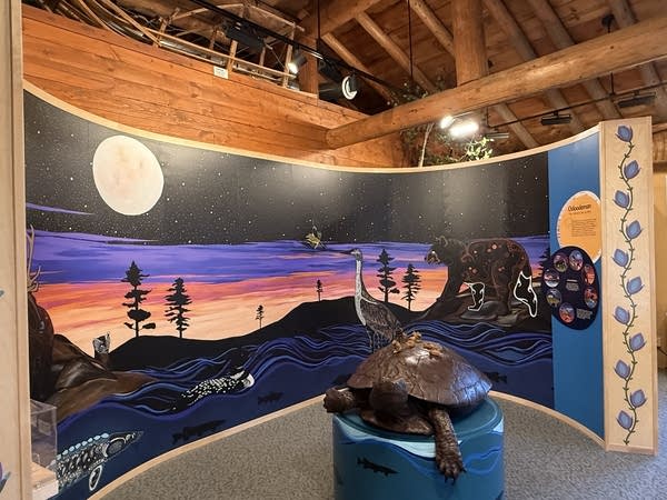 A bronze turtle with a mural behind it