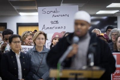 A person holds up a sign