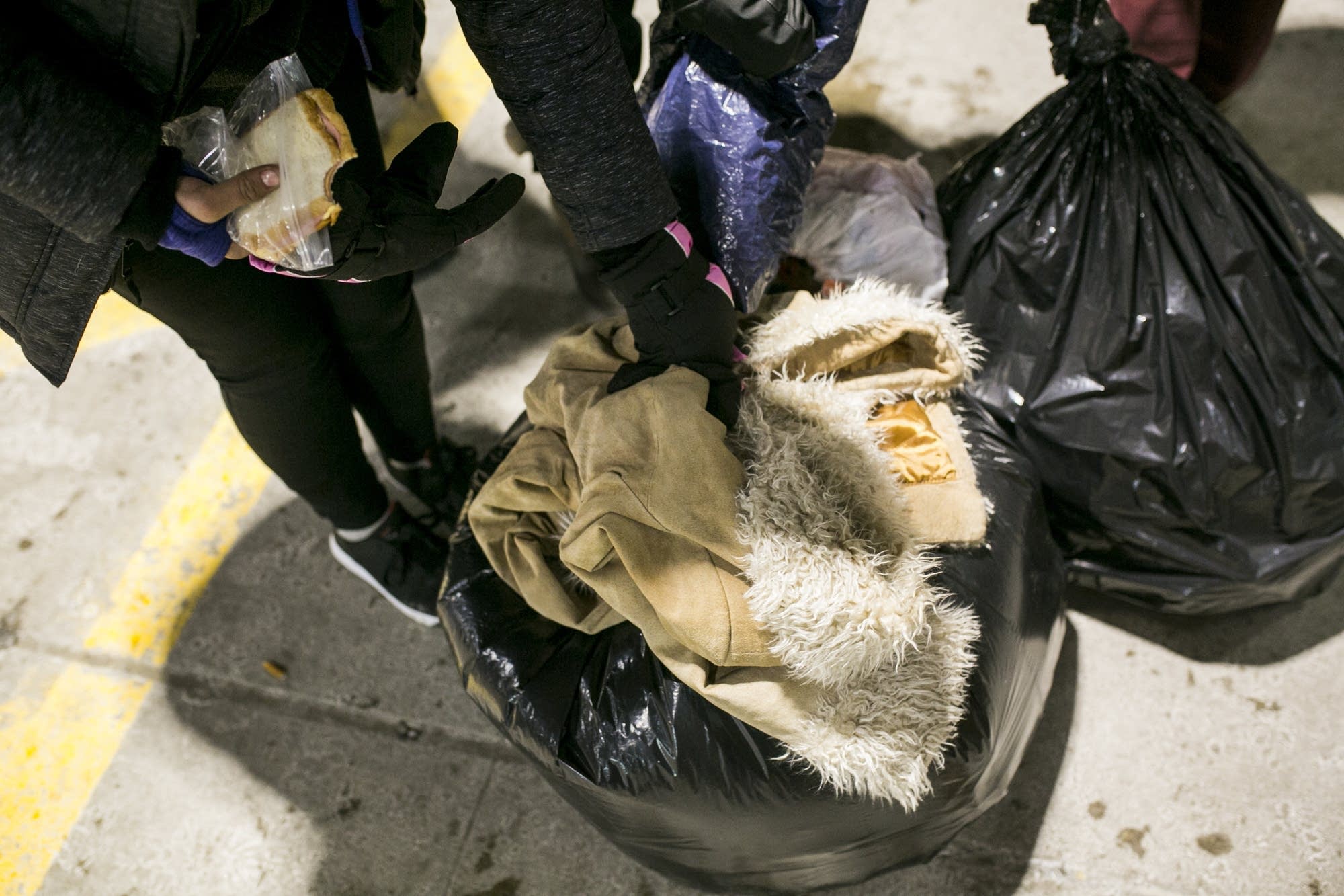Nakehia Cotton and others grab bags of coats and other possessions