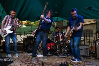 a rock band performing on an outdoor stage